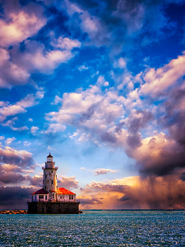 Chicago Lighthouse on cloudy day with sunlight breaking through clouds